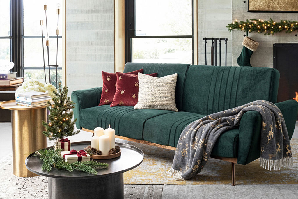 Sofá verde con decoración navideña, cojines cálidos y mesa auxiliar con adornos de Navidad Decoración de Navidad